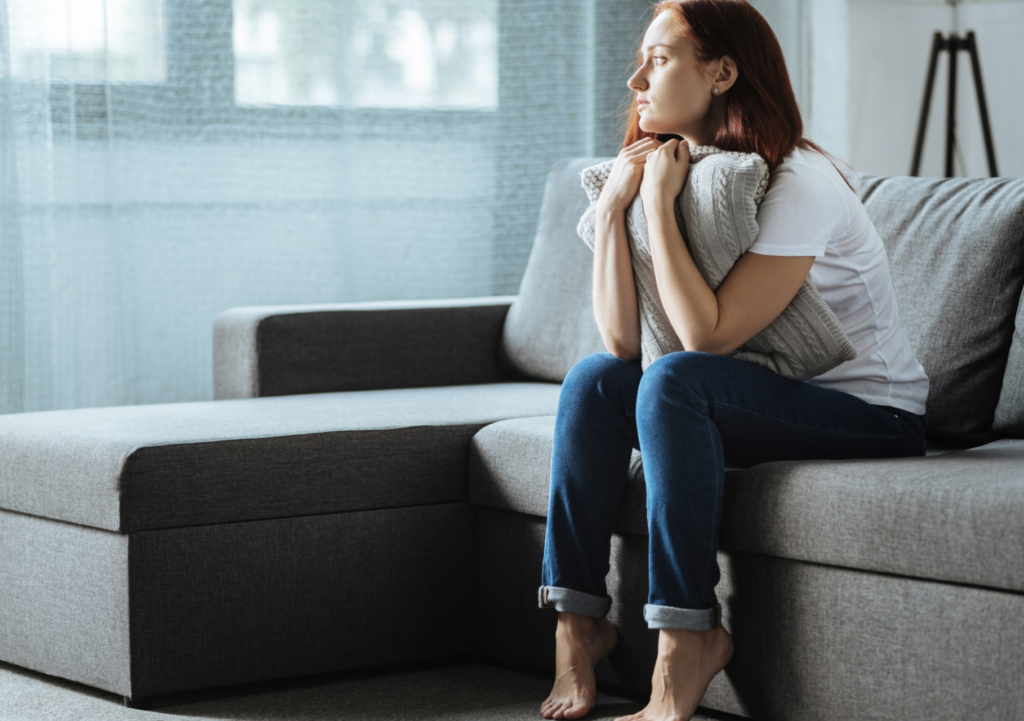 Mladá žena se zavřenýma očima opřená o&nbsp;ruku u&nbsp;notebooku v&nbsp;kanceláři, vyjadřující totální vyčerpání a&nbsp;syndrom vyhoření z&nbsp;neustálého dokazování vlastní hodnoty.